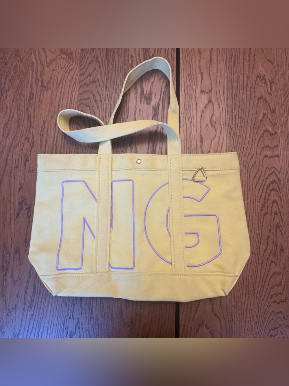 BaubleBar Alpha Custom Tote is made from yellow canvas embroidered letters N G